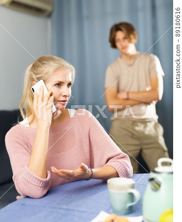 Housewife speak by mobile phone in home interior 89180616