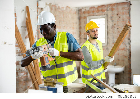 Man builder using electric hammer in construction site 89180815