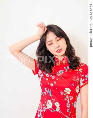 Young asian woman in traditional cheongsam feeling tired and bad spirit with headache touching head discomfort in front of white background. 89181274