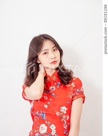 穿著傳統旗袍的年輕亞洲女性,在白色背景前因為頸部不舒服按摩著頸部. 89181286