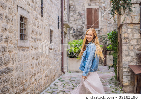 Woman tourist enjoying Colorful street in Old town of Kotor on a sunny day, Montenegro. Travel to Montenegro concept 89182186
