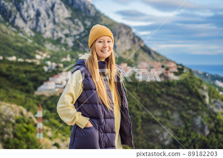 Woman in the mountains of Montenegro in warm clothes. Travel to Montenegro in spring, autumn, winter Woman in the mountains of Montenegro in warm clothes. Travel to Montenegro in spring, autumn, winter 89182203