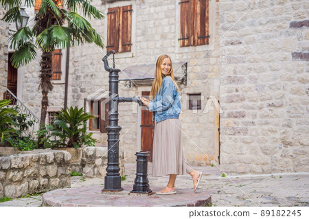 Woman tourist enjoying Colorful street in Old town of Kotor on a sunny day, Montenegro. Travel to Montenegro concept 89182245