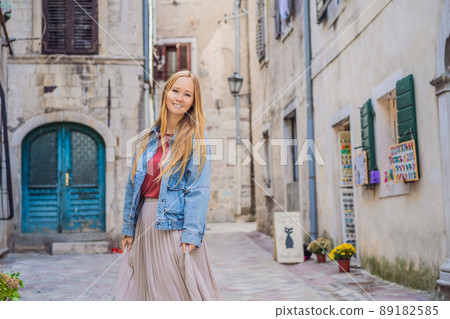 Woman tourist enjoying Colorful street in Old town of Kotor on a sunny day, Montenegro. Travel to Montenegro concept Woman tourist enjoying Colorful street in Old town of Kotor on a sunny day, Montenegro. Travel to Montenegro concept 89182585
