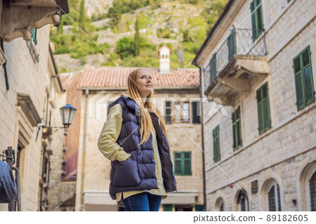Woman tourist enjoying Colorful street in Old town of Kotor on a sunny day, Montenegro. Travel to Montenegro concept 89182605