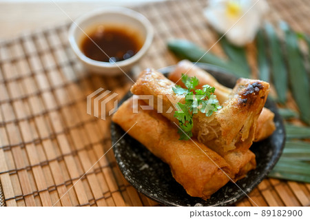 Tasty Asian vegetables spring rolls on a minimal black plate 89182900
