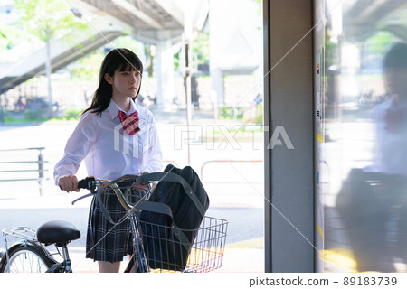 High school girls riding a bicycle elevator and going to school by bicycle Residential area urban area 89183739
