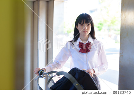 High school girls riding a bicycle elevator and going to school by bicycle Residential area urban area 89183740
