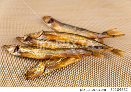 Smoked capelin against a beige background. Five ready-to-eat little fish. Seafood. Smoked capelin against a beige background. Five ready-to-eat little fish. Seafood. 89184282