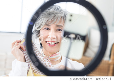 Senior woman Senior woman shooting a video on her smartphone Senior woman Senior woman shooting a video on her smartphone 89184691