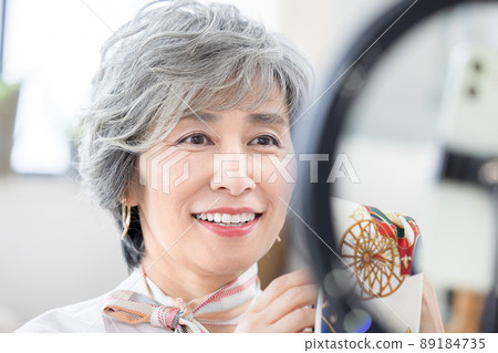 Senior woman Senior woman shooting a video on her smartphone Senior woman Senior woman shooting a video on her smartphone 89184735