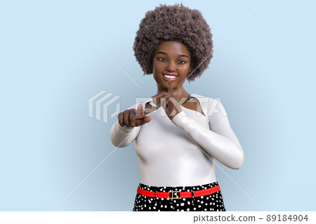 一個留著圓形捲髮的黑人婦女指著前面，把食指舉到嘴邊 89184904