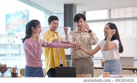Startup business team stacking hands over table, showing group unity, celebrating successful teamwork or achievement. 89185428