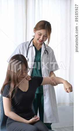 Shot of physiotherapist examining female patient with arms injuries in clinic. Physical therapy concept. 89185927