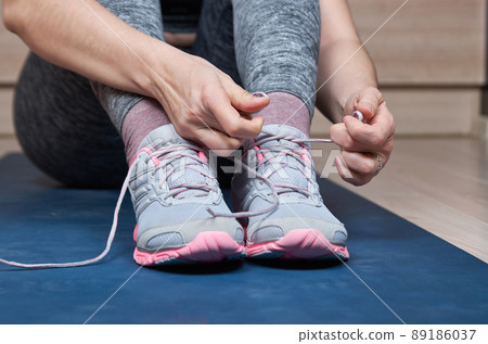 Sports woman tying her shoelaces 89186037