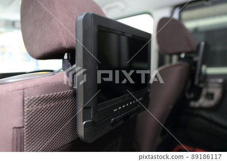 Headrest monitor attached to the rear seat in the car Headrest monitor attached to the rear seat in the car 89186117