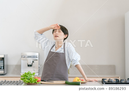 Kitchen woman headache tired fever 89186293