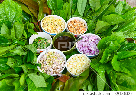 Miang Kham Or wild betel leaves wrap ingredients with lemon grass, garlic, shallot, lime, chilli, roasted peanuts with sweet dipping sauce, Asian appetizer food. Miang Kham Or wild betel leaves wrap ingredients with lemon grass, garlic, shallot, lime, chilli, roasted peanuts with sweet dipping sauce, Asian appetizer food. 89186322