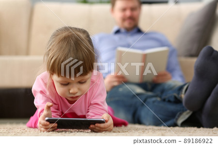 Little girl kid watching cartoon on smartphone device, digital entertainment for child Little girl kid watching cartoon on smartphone device, digital entertainment for child 89186922