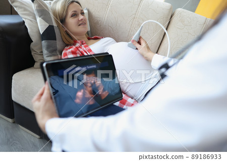 Gynecologist doing ultrasound scan on belly using modern digital ultrasound machine with tablet 89186933