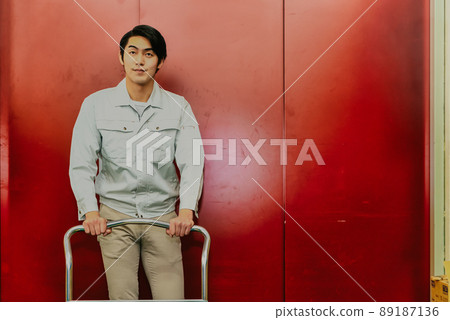 一名男子在貨梯前推著小車 89187136