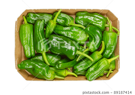 Raw Padron peppers, also called Herbon peppers, in a cardboard tray. Variety of Capsicum annuum from the municipality of Padron in northwestern Spain. Small, green, mild peppers with elongated shape. Raw Padron peppers, also called Herbon peppers, in a cardboard tray. Variety of Capsicum annuum from the municipality of Padron in northwestern Spain. Small, green, mild peppers with elongated shape. 89187414