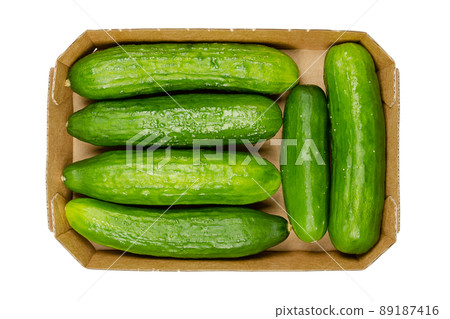 Fresh snack cucumbers, in a cardboard tray. Small, young and whole cucumber fruits, crunchy and ready to eat. Cucumis sativus, a vegetable. Close-up, from above, isolated over white, food photo. 89187416