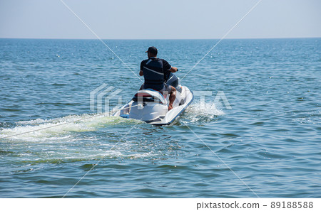 Teen age boy skiing on water scooter. Young man on personal watercraft in tropical sea. Active summer vacation for school child. Sport and ocean activity on beach holiday 89188588