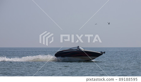 a small motor boat floats on the shocking surface of the sea a small motor boat floats on the shocking surface of the sea 89188595