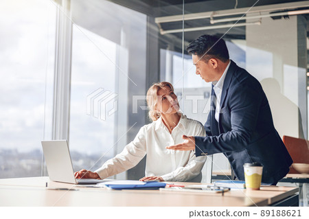 confident business partners discussing plans and strategy in light modern office 89188621
