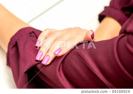 Beautiful manicure with purple, pink nail polish on young caucasian female hands Beautiful manicure with purple, pink nail polish on young caucasian female hands 89188929