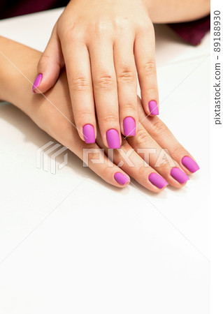 Beautiful manicure with purple, pink nail polish on young caucasian female hands Beautiful manicure with purple, pink nail polish on young caucasian female hands 89188930