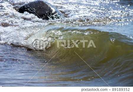 Sea wave with spray and foam near the shore 89189352
