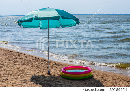 Inflatable pool on the beach with umbrella 89189354