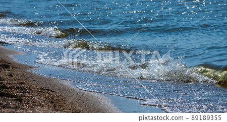 Sea wave with spray and foam near the shore Sea wave with spray and foam near the shore 89189355