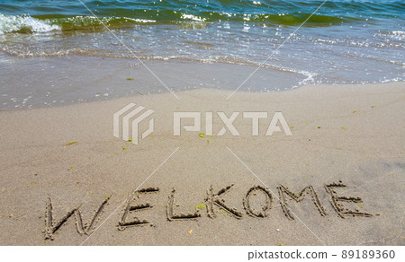 Handwritting inscription welkome word on tropical sandy beach, travel concept card for holidays Handwritting inscription welkome word on tropical sandy beach, travel concept card for holidays 89189360