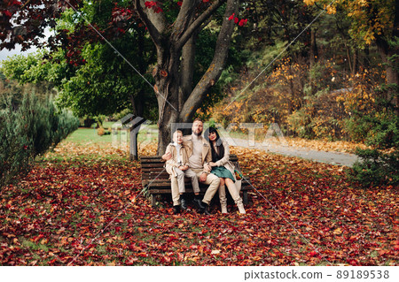 A happy family is walking in the park. Mom, dad 89189538