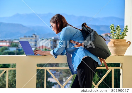 Confident serious mature business woman with laptop outdoors. Confident serious mature business woman with laptop outdoors. 89190027