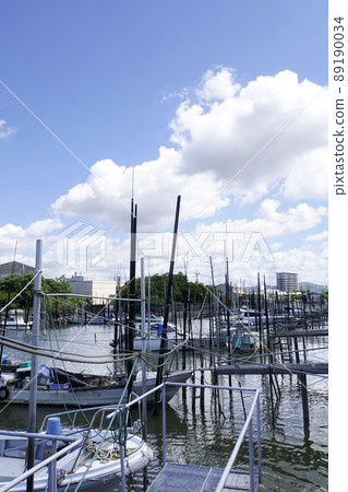 White clouds in the blue sky and a fishing boat moored in the Omuta River White clouds in the blue sky and a fishing boat moored in the Omuta River 89190034