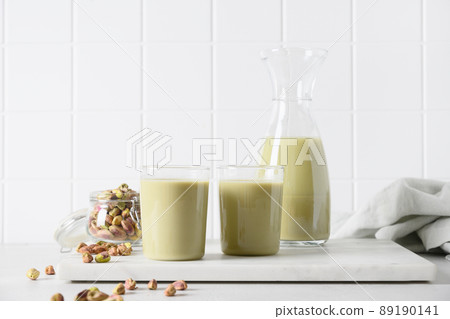 Pistachio nut milk in glass, lactose free. Vegan nutty plant based milk. Pistachio nut milk in glass, lactose free. Vegan nutty plant based milk. 89190141