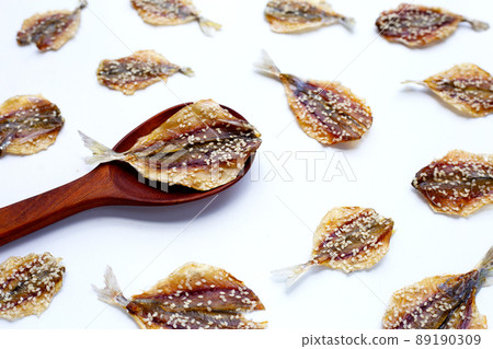 Dried fish with sesame seeds on white background. 89190309