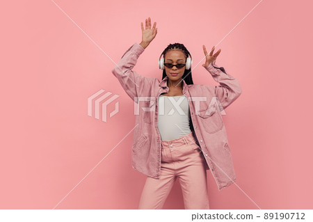 Monochrome portrait of young attractive happy woman in casual style outfit dancing isolated on pink background. Concept of beauty, art, fashion, youth, style 89190712