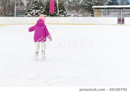 little girl ice skating on the ice rink 89190798