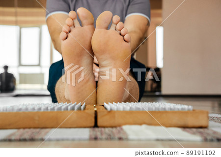 Feet and wooden board with sharp metal nails. Sadhu foot board. Yoga relaxation practice training Feet and wooden board with sharp metal nails. Sadhu foot board. Yoga relaxation practice training 89191102