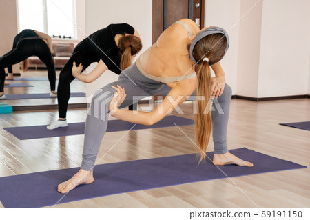 Group Of women Doing Yoga Pose At Studio, making sport exercises together Group Of women Doing Yoga Pose At Studio, making sport exercises together 89191150