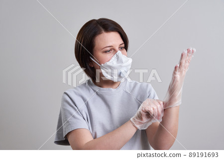 Young woman wearing face mask for protection from coronavirus over grey background with copy space 89191693