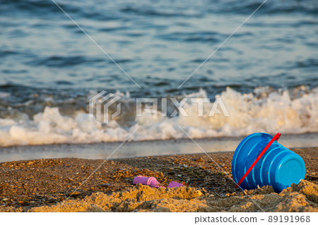 Children's toys on a sandy beach, blue sky and the sea in the background Children's toys on a sandy beach, blue sky and the sea in the background 89191968