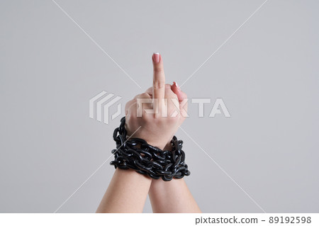 Female chained fist showing a fuck you sign Female chained fist showing a fuck you sign 89192598
