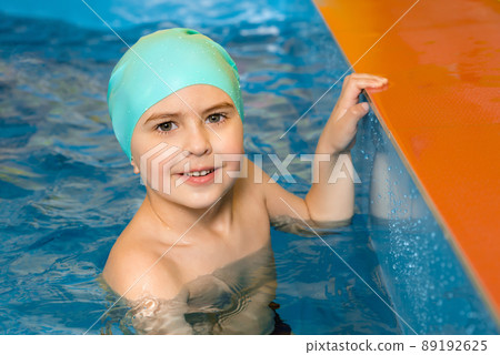 Boy swimming in indoor pool having fun during swim class 89192625
