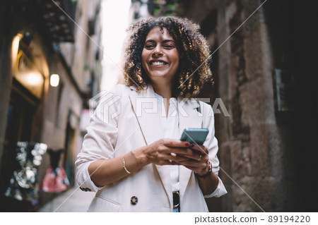 Happy Caucasian tourism with cellular device smiling at camera Happy Caucasian tourism with cellular device smiling at camera 89194220